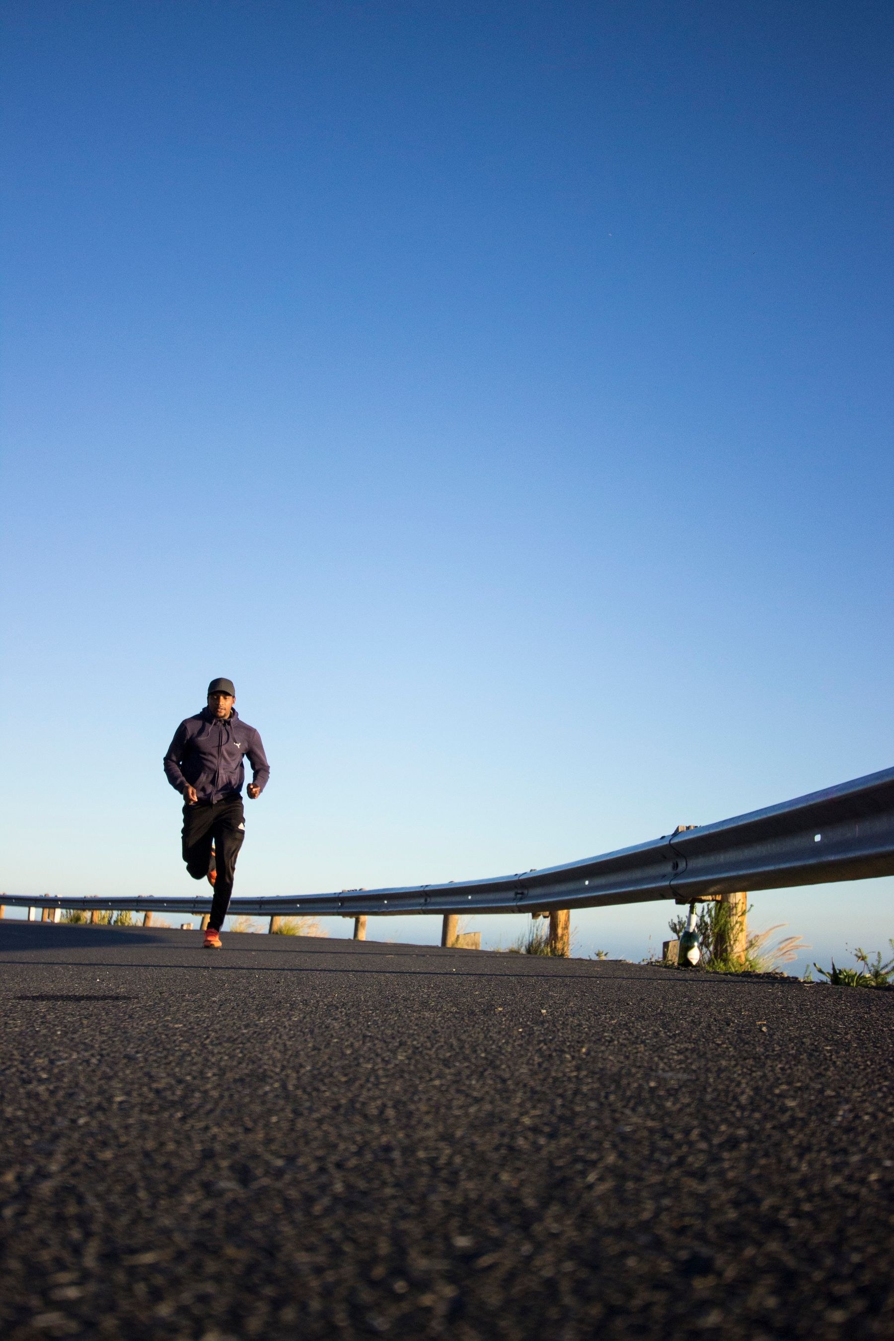 A runner moving outdoors beneath a clear blue sky