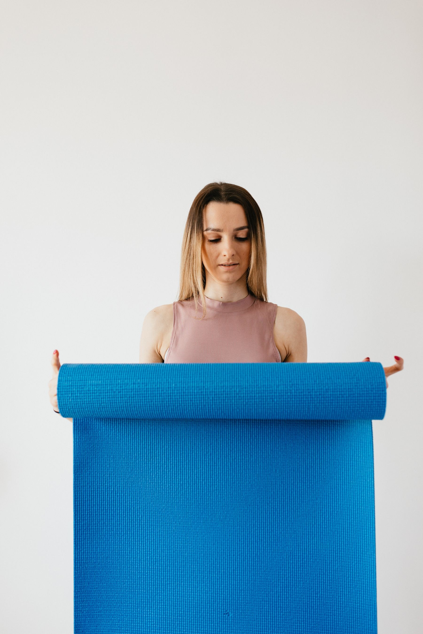 A woman preparing an exercise mat for her daily routine